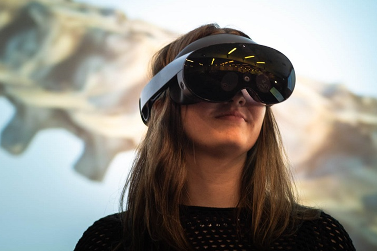 A woman wearing a virtual reality goggles.