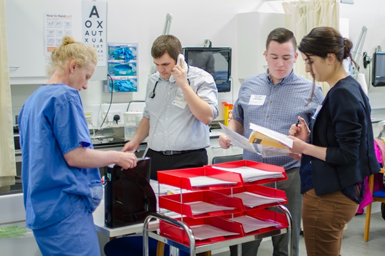 A group of people standing in a hospital ward.