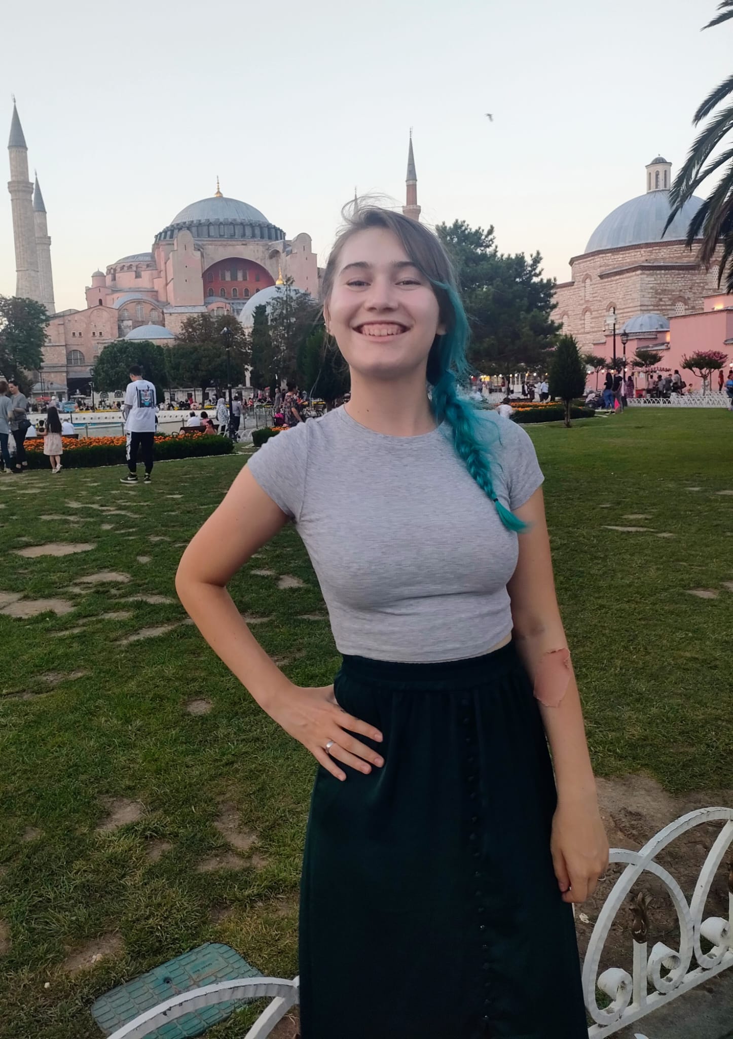 An image of a young woman standing in front of a mosque in Turkey.