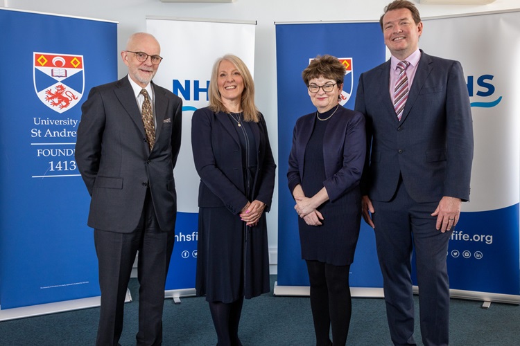 Image of Professor David Crossman, Carol Potter, Professor Dame Sally Mapstone and Dr Chris McKenna standing together in front of University of St Andrews and NHS Fife banners.